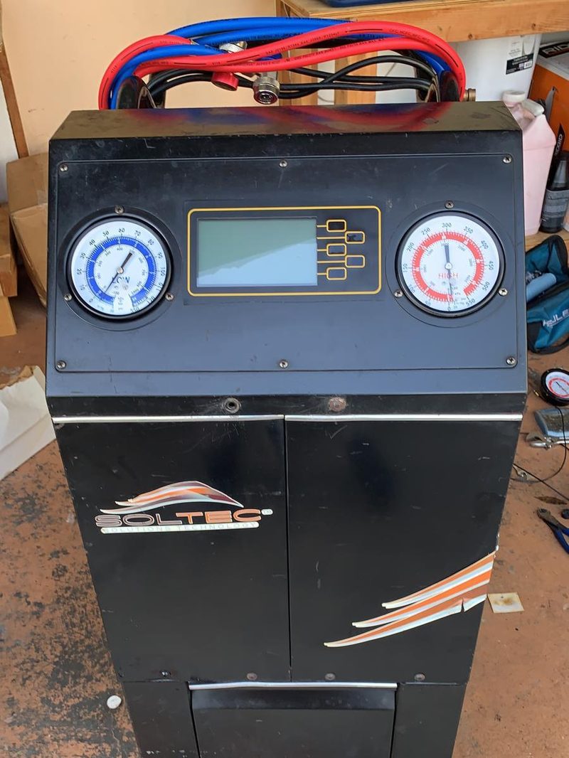 Close-up of a serviced A/C recovery machine, pressure gauges and digital display
